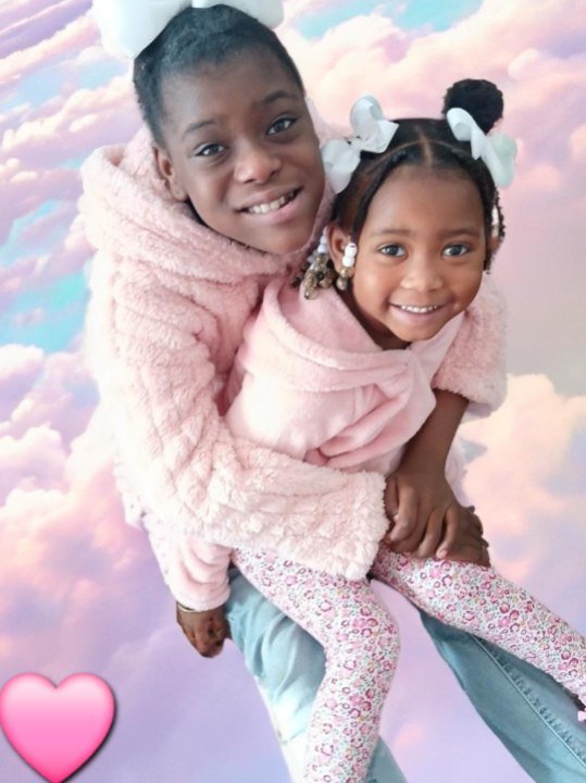 Legend and Grace smiling together in pink jackets